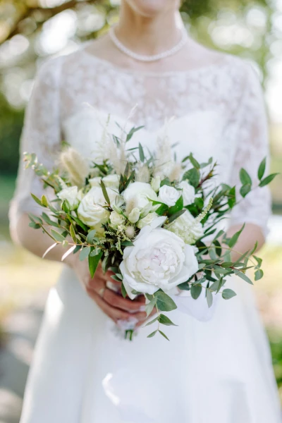 bouquet de mariée blanc beige et vert tenu par la mariée