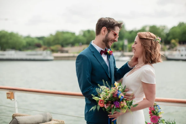 couple de mariés sur un bateau se regarde et se sourit