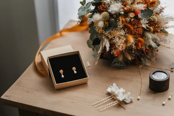 les accessoires et bijoux de la mariée sont posés sur une table près de son bouquet