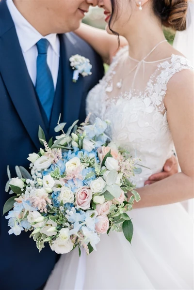 couple enlacé avec le bouquet de mariée entre eux