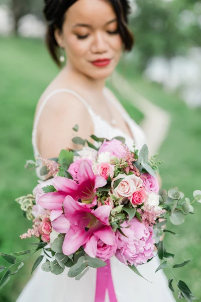 mariée tient son bouquet de mariée composé de fleurs roses