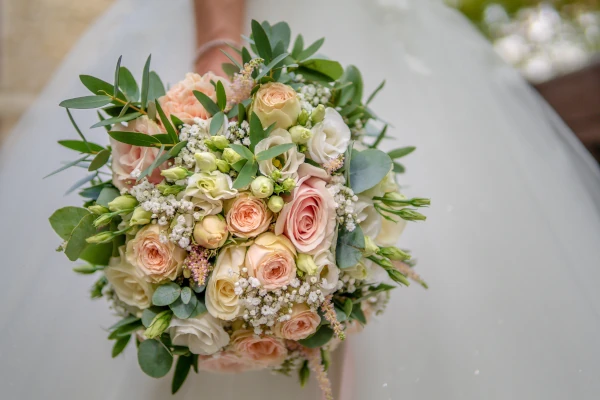 bouquet de mariée pastels tenu par une main