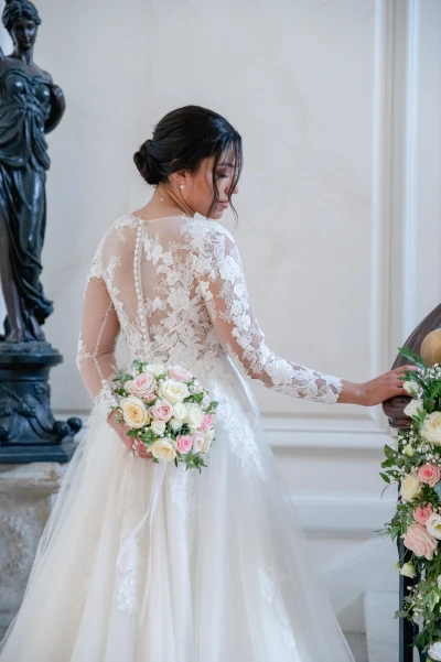 mariée monte des marches son bouquet de mariée dans son dos