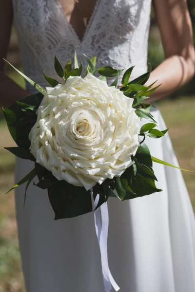 la mariée tient son bouquet de mariée qui est une rose géante