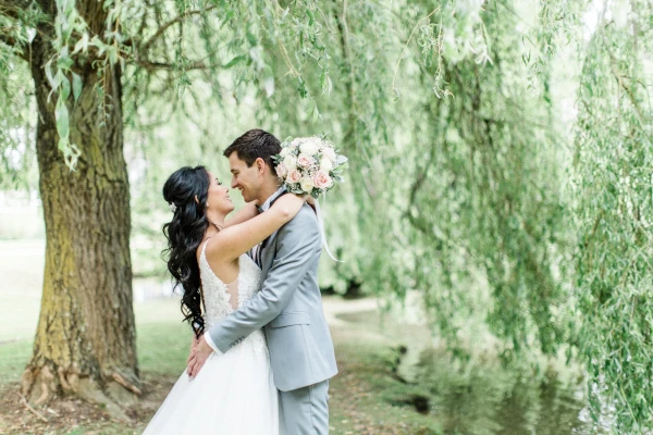 couple enlacé en extérieur avec bouquet pastel