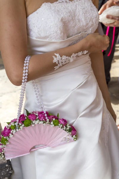 mariée tient un bouquet suspendu à son bras comme un sac