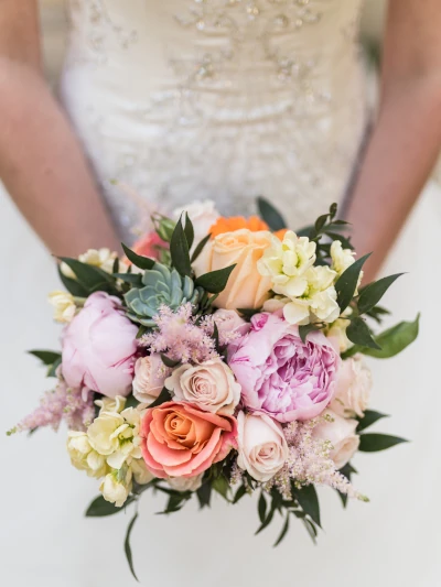 mariée tient un bouquet de mariée multicolore et pastel