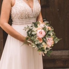 Bouquet de mariée champêtre tons blancs, roses pâles et pêches en pivoines, roses et feuillages champêtres.