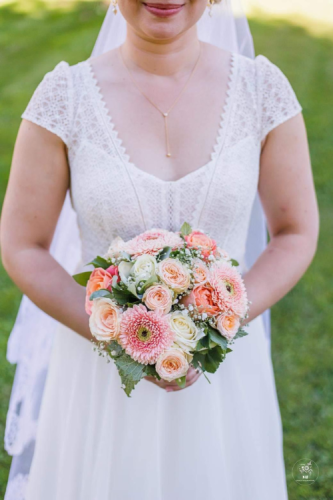 Bouquet de mariée colorée en roses et marguerites dans les tons pêches corails et oranges.