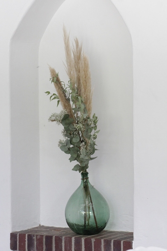 Dame jeanne fleurie avec pampa et eucalyptus décor bohème aromatique fleuriste mariage
