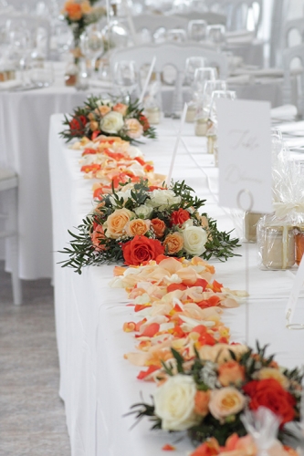 Décor floral pour la table d'honneur avec composition centrale et rappel aux extrémités aromatique fleuriste mariage