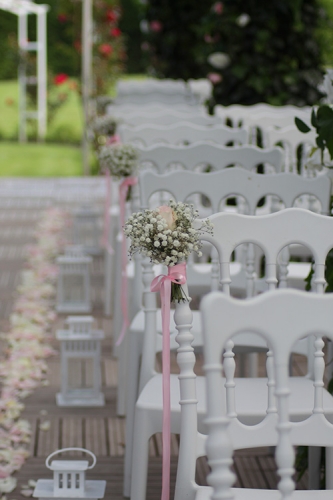 Allée de cérémonie décorée de bouquet de roses et gypsophile, pétales de roses, et lanterne aromatique fleuriste mariage