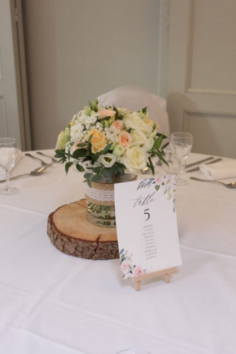 Bouquet de roses dans un vase sur un rondin