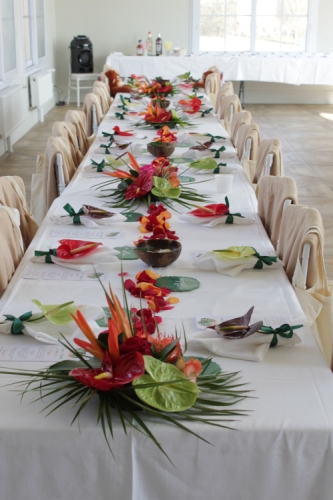 Longue table décorée de compositions florales exotiques