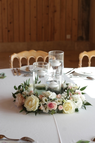 Couronne fleurie autour d'un trio de vases