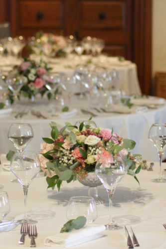 Centre de table en fleurs roses surélevé par un petit vase