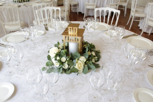 Centre de table en fleurs blanches et eucalyptus autour d'une lanterne