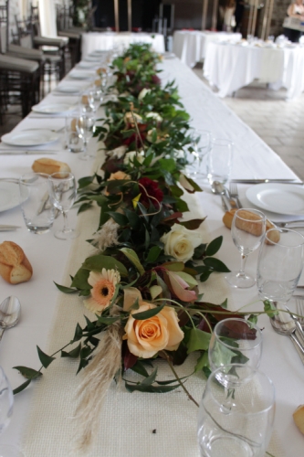 Longue guirlande de feuillages et fleurs sur la table