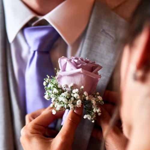Une rose mauve en boutonnière aromatique fleuriste mariage